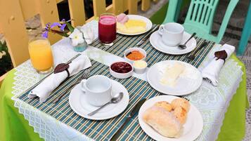 A table set for breakfast with plates of food, a glass of juice, and a cup of coffee.