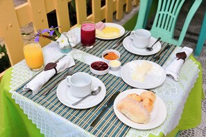 Una mesa lista para el desayuno, con platos de comida, un vaso de jugo y una taza de café.