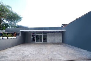 Ein modernes Gebäude mit flachem Dach, einem Betoninnenhof und einem Glas Eingangsbereich.