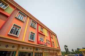 Un hotel de varios pisos con una fachada vibrante, ventanas amplias y una señalización visible que indica que es un hotel.