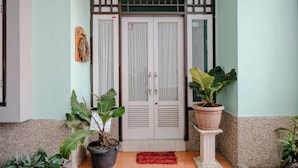 A building entrance with a double door, potted plants, and a tiled floor. - Spot On 2046 Villa Hardi (Batu)