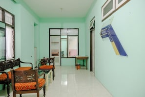 Una habitación con una mesa de comedor, sillas, un sofá y una ventana con cortinas.