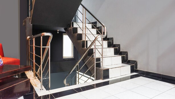 A modern staircase with a glass railing and black and white tiles. - Ht O Makassar Near Mall Panakukkang (Makassar)