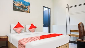 A hotel room with a bed, a nightstand, a desk, a chair, a door, and a wall-mounted picture. - Ht O Makassar Near Mall Panakukkang (Makassar)
