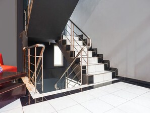 A modern staircase with a glass railing and black and white tiles. - Ht O Makassar Near Mall Panakukkang (Makassar)