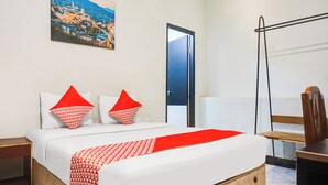 A hotel room with a bed, a nightstand, a desk, a chair, a door, and a wall-mounted picture. - Ht O Makassar Near Mall Panakukkang (Makassar)