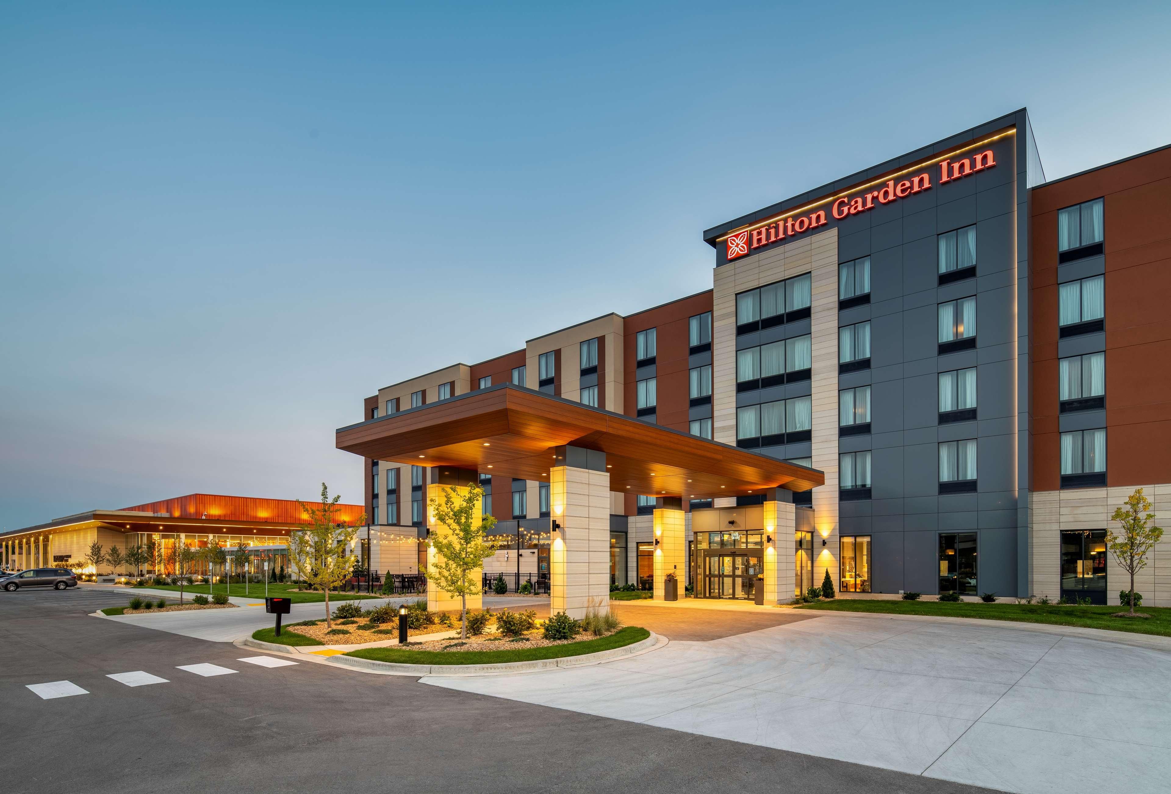 A modern hotel with a prominent entrance, multiple floors, and a well-lit facade.
