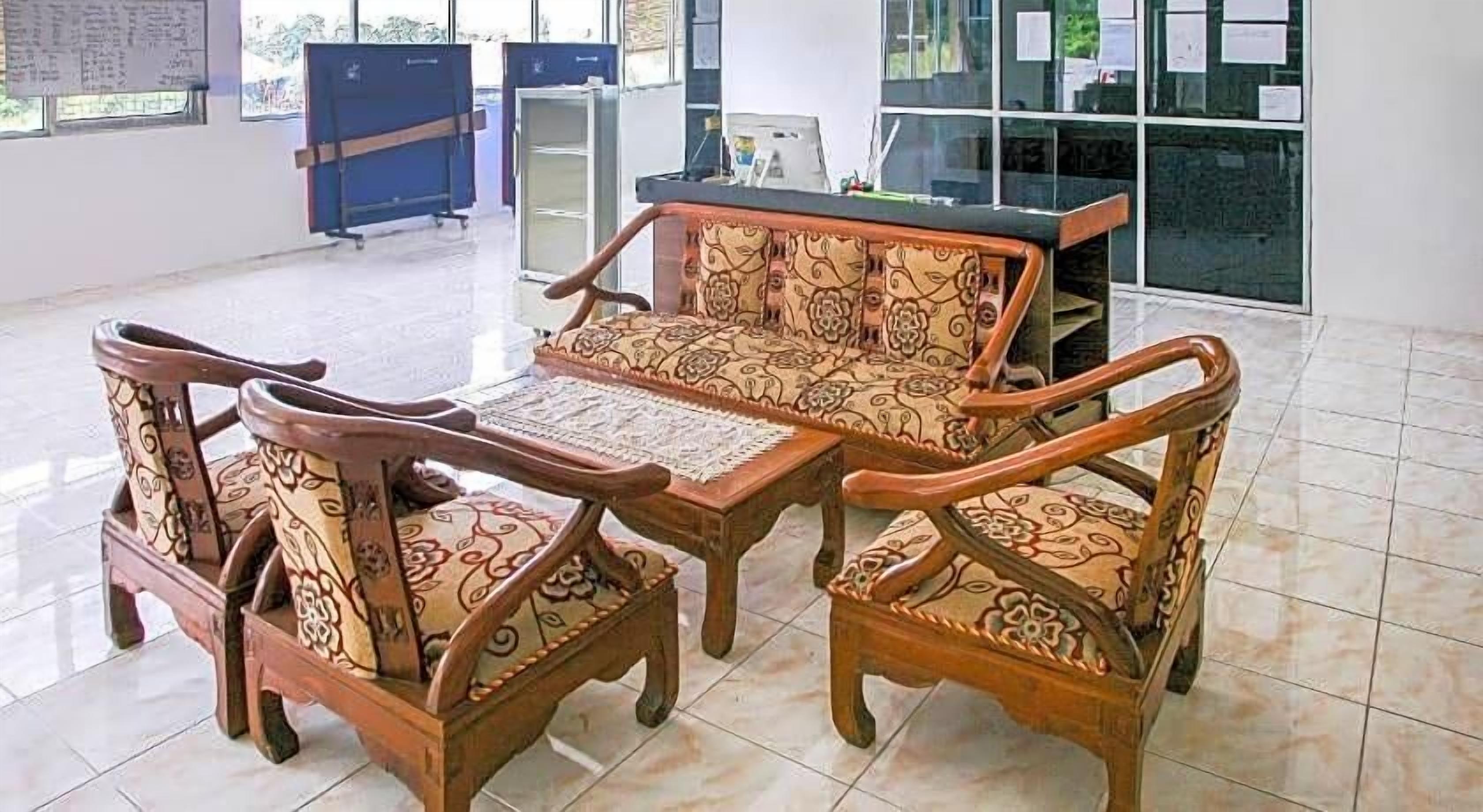A seating area with a sofa and chairs, a small table, and a cabinet.