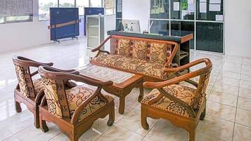 A seating area with a sofa and chairs, a small table, and a cabinet.