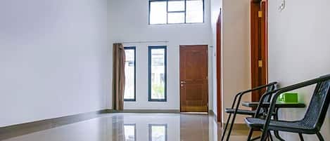 A hallway with a polished floor, two doors, and a bench.