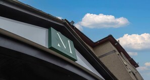 A clock on a building's facade, indicating a time of approximately 10:10.