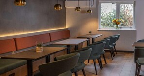 Ein modernes Restaurantambiente mit Sitzecken, Tischen und Stühlen.