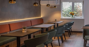 Un interior de restaurante moderno con cabinas, mesas y sillas.