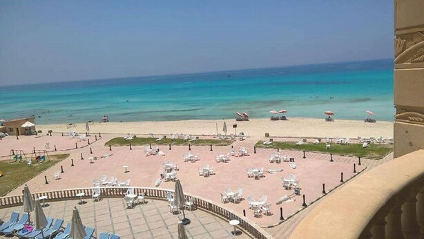 A beachside hotel with outdoor seating areas, a pool, and a view of the ocean. - Royal Sea View (Alexandria)