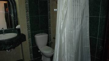 A bathroom with a sink, toilet, and shower curtain.