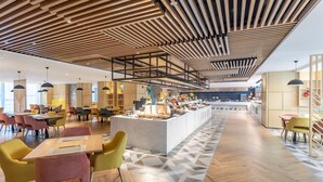 A modern interior with a central island, wooden ceiling, and a geometric patterned floor.