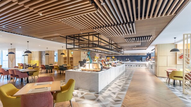 A modern interior with a central island, wooden ceiling, and a geometric patterned floor. - Holiday Inn Xian High Tech Zone (Xi'an)