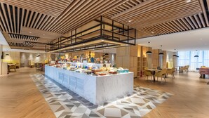 A spacious hotel lobby with a central buffet, wooden ceiling design, and modern furniture. - Holiday Inn Xian High Tech Zone (Xi'an)