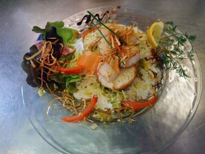 Un plato con mariscos y diferentes verduras.