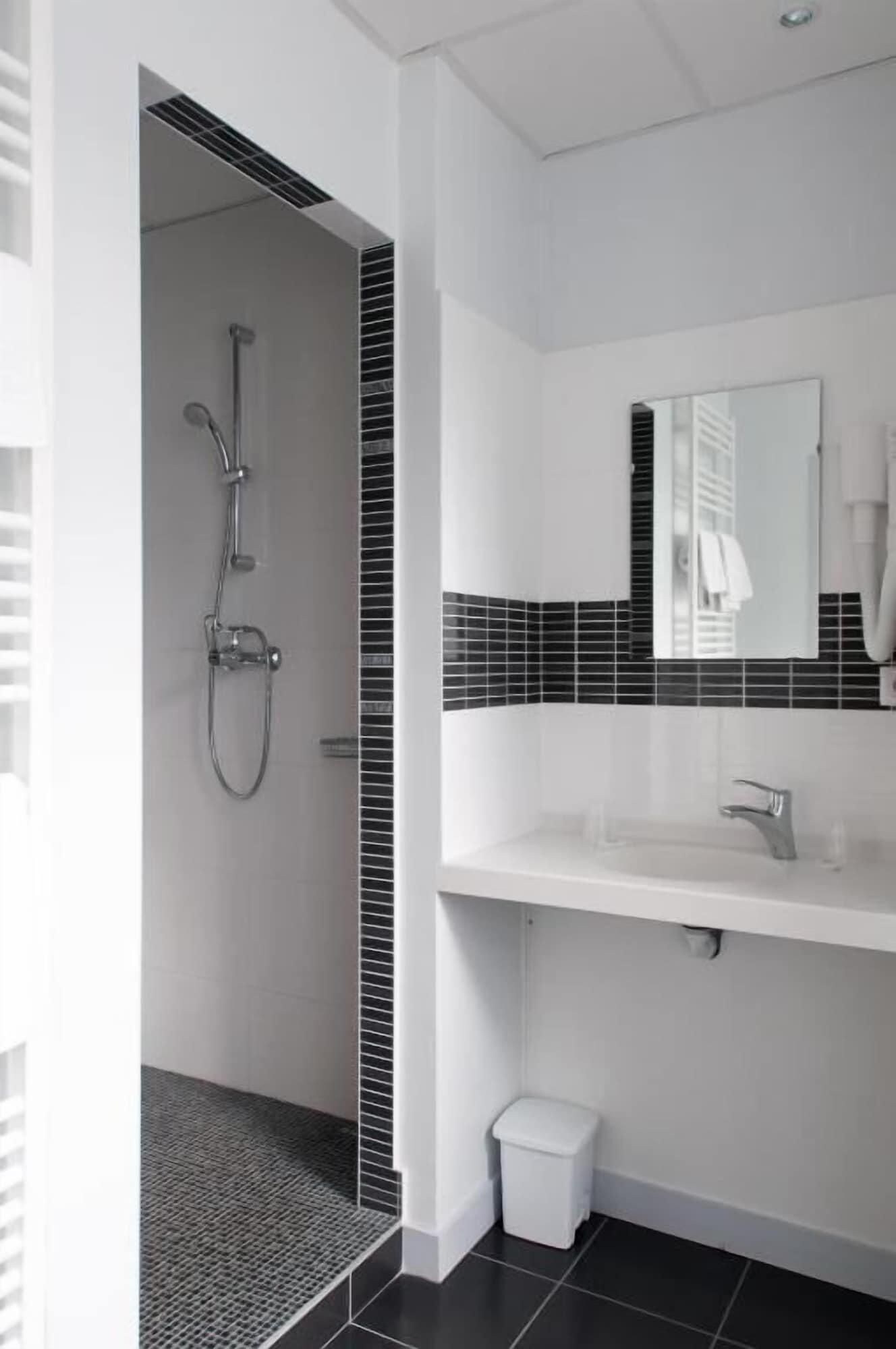 Une salle de bain moderne équipée d’une douche, d’un lavabo et de toilettes.