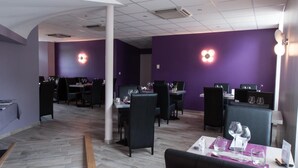 A restaurant with purple walls, multiple tables, and chairs. - Hôtel du Parc, Rte Le Rouget de Lisle (Lons-le-Saunier)