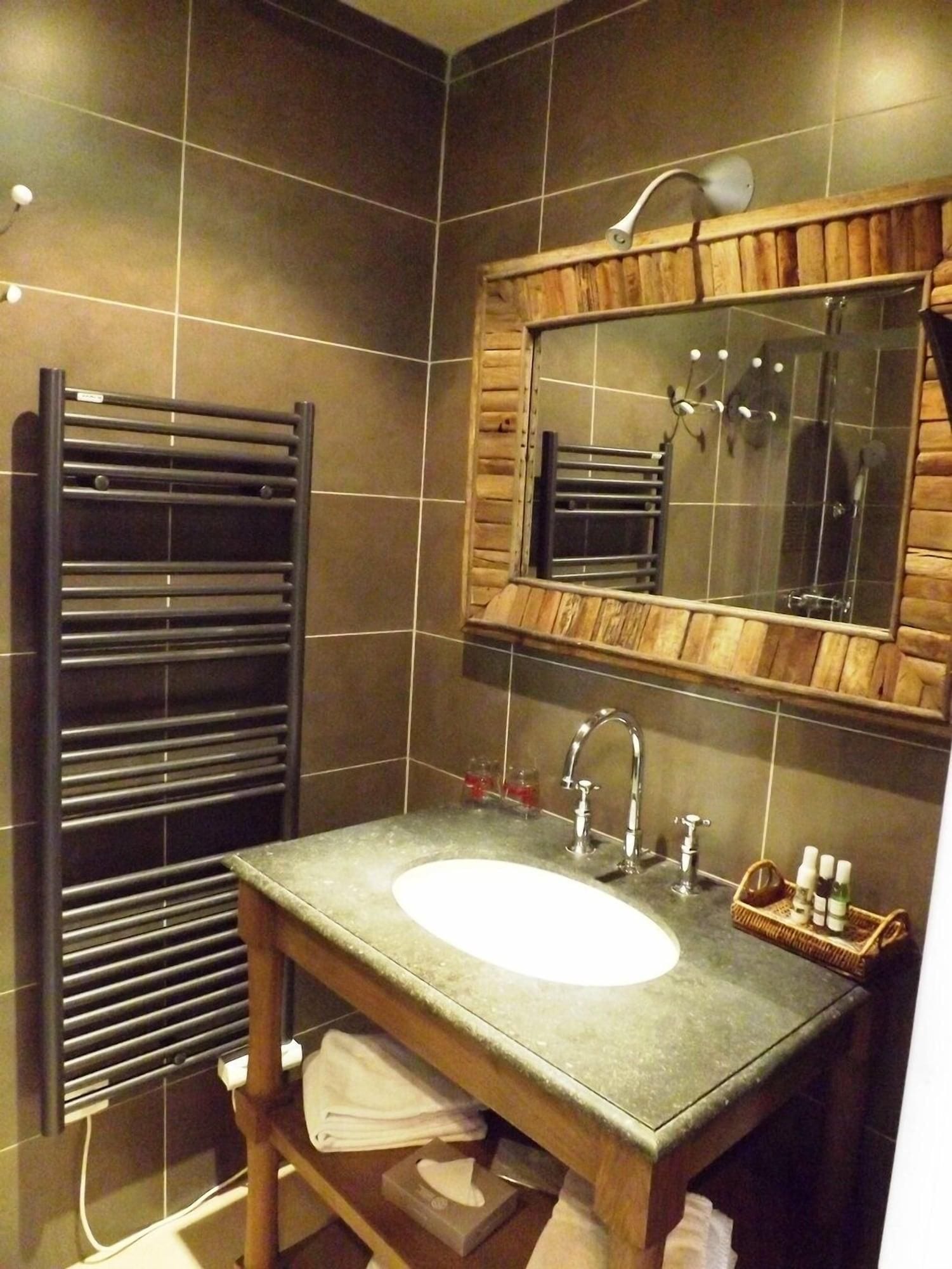 A modern bathroom with a large mirror, a sink, and a towel rack.