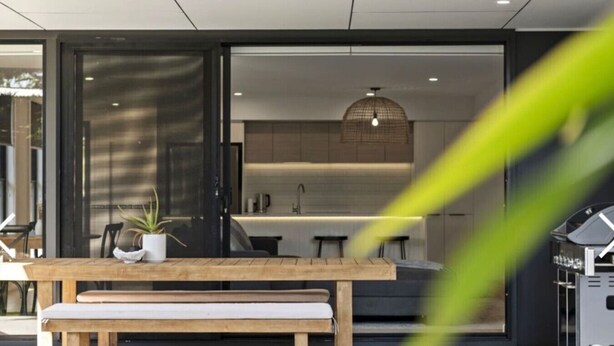 Une cuisine moderne avec un coin repas, un banc et une plante en pot.