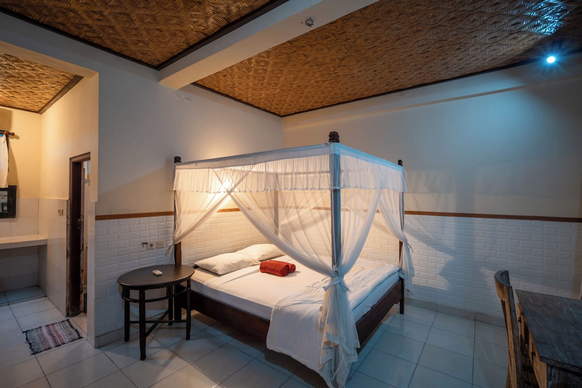 A room with a bed, a small table, and a chair.
