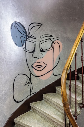 A staircase with a handrail and a wall with a simple line drawing. - Taksim Terrapia Hotel (Istanbul)