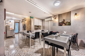 A modern dining area with checkered tablecloths, black chairs, and a stone accent wall. - Taksim Terrapia Hotel (Istanbul)