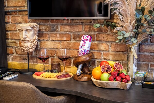 A bar area with a brick wall, a mounted TV, and a variety of food and drink items on the counter. - Taksim Terrapia Hotel (Istanbul)