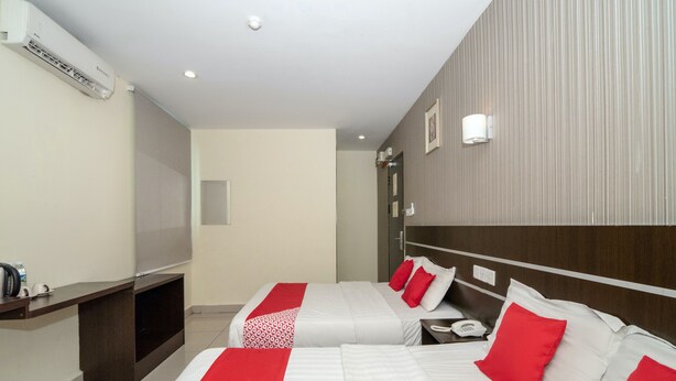 A hotel room with two beds, a TV, a phone, and an air conditioning unit. - OYO 89965 Stay Inn Ii (Kota Kinabalu)