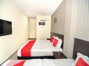 A hotel room with a bed, a TV, an air conditioning unit, and a small table. - OYO 89965 Stay Inn Ii (Kota Kinabalu)