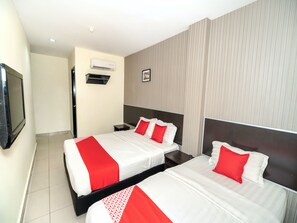 A hotel room with two beds, a flat-screen TV, an air conditioning unit, and a framed picture on the wall. - OYO 89965 Stay Inn Ii (Kota Kinabalu)