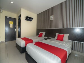 A hotel room with two beds, each with red and white bedding, a dark headboard, and a striped wall. - OYO 89965 Stay Inn Ii (Kota Kinabalu)