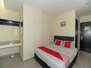 A hotel room with a bed, a bedside table, a mirror, a door, and a picture on the wall. - OYO 89965 Stay Inn Ii (Kota Kinabalu)
