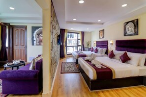 A hotel room with two beds, a purple sofa, a wooden floor, and artwork on the walls. - Sumitel Sanderling, Darjeeling (Darjeeling)
