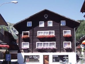 A two-story building with multiple windows and flower boxes on the upper floor. - Fontauna Degonda, (Sedrun), 235.01 by Interhome (Sedrun)
