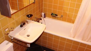Un baño con lavamanos, espejo y bañera.