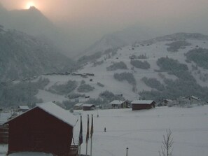 Schneebedeckte Landschaft mit H äusern und einem Berg im Hintergrund.