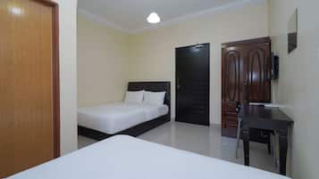 Een hotelkamer met een bed, een bureau, een kledingkast en een deur.