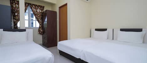 Habitación de hotel con dos camas, un armario, aire acondicionado y ventana con cortinas florales.