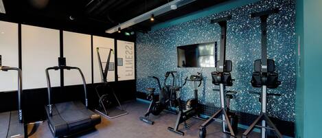 A gym with treadmills, elliptical machines, and weight stations.