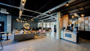 Un interno moderno con una reception, un'area salotto e un'ampia parete con un logo.