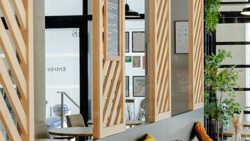 Ein modernes Interieur mit Sitzbereichen, Tischen und einer sichtbaren Speisekarte.