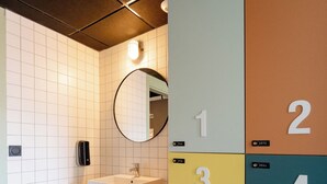 Des toilettes équipées d’un lavabo, d’un miroir et de casiers numérotés.
