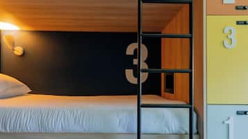 A bunk bed with a ladder, a bedside table, and a wardrobe with numbered compartments.