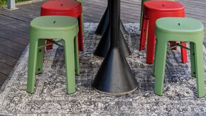 Une table ronde entourée de tabourets, une enseigne indiquant « HEURE HEUREUSE DE 18 H À 20 H », et un panneau affichant le menu en arrière-plan.