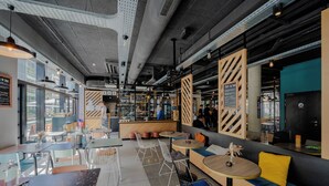 Un caffè moderno con zone salotto, un bancone bar e vista sulla strada.