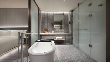 A modern bathroom with a freestanding bathtub, a large mirror, and a glass shower enclosure.